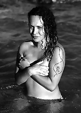 Nikki strips off naked in a spanish beach exposing her nice tits and give her dick a splash